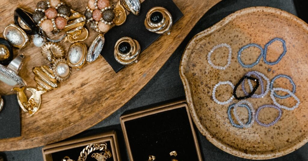 Top view of assorted handmade earrings, rings, and bracelets on ceramic and wooden trays.
